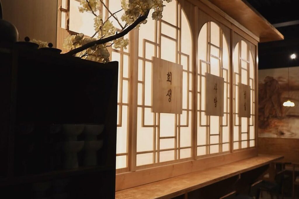 Rice Thief's dining room with hanji screens and cherry blossom branches