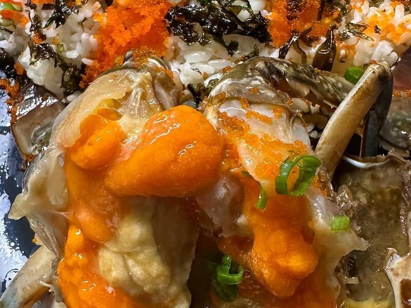 Crab roe and meat scooped over rice with fish roe and scallions