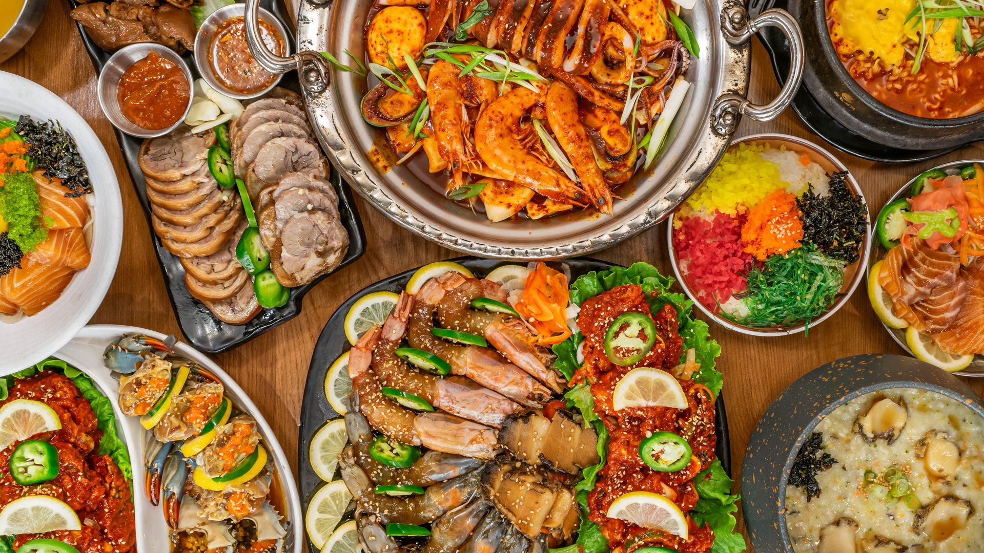 A table spread of marinated crab, shrimp and abalone, braised pig trotters, a seafood hot pot and abalone porridge